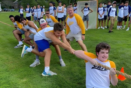 Estudiantes de The Salisbury School participan en una actividad de construcción de equipo en un prado.