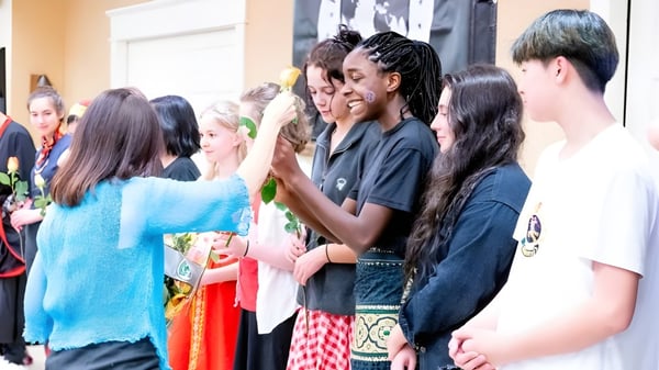 Un grupo diverso de estudiantes y adultos se reúne en una sala común de The Stony Brook School.