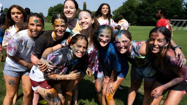Los estudiantes de The Taft School celebran juntos al aire libre y están cubiertos de colores brillantes.