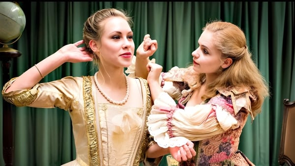 Dos mujeres en trajes históricos realizan una representación teatral frente a un telón verde en el campus de la The Yehudi Menuhin School.