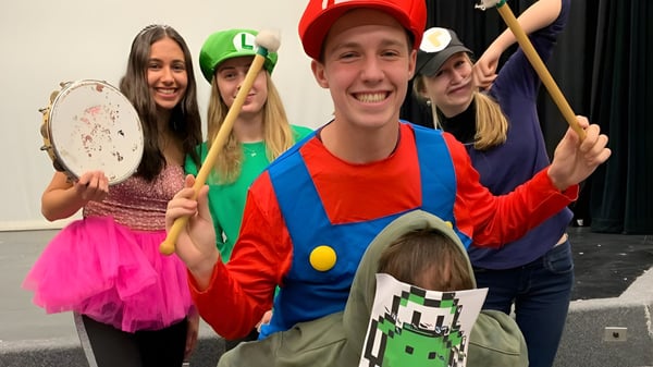 Un grupo de estudiantes de la Thomas A. Blakelock High School en coloridos disfraces durante una actuación lúdica.