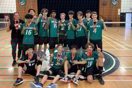 Un grupo de jóvenes deportistas en camisetas verdes en el campo de baloncesto de la Thomas A. Blakelock High School.