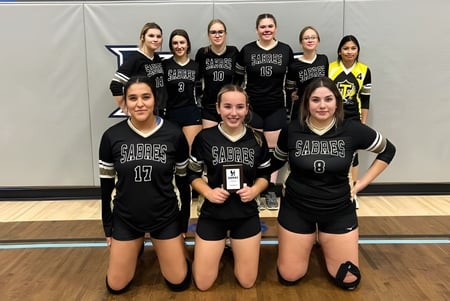 Un grupo de jóvenes estudiantes en uniformes deportivos posan juntas en el gimnasio de la Thorsby Junior Senior High School.