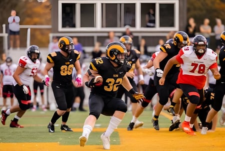 Un grupo de jugadores de fútbol de la Tilton School está en el campo deportivo durante un intenso partido.