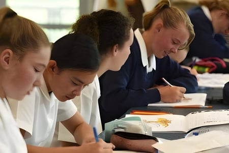 Las alumnas de la Timaru Girls School se concentran en su trabajo con libros y papeles en clase.