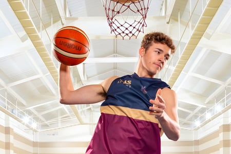 Un estudiante de la Toowoomba Anglican School sostiene un baloncesto frente al aro en la cancha.