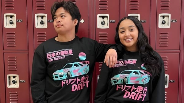 Dos estudiantes están frente a taquillas rojas en el campus de la Torrance High School.