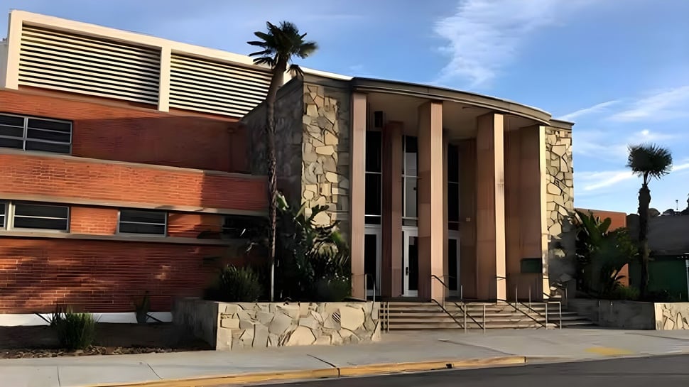El moderno edificio de varios pisos con fachada de piedra y grandes ventanas se encuentra en el campus del Torrance Unified School District.