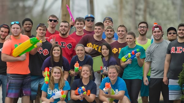 Estudiantes de la Trine University participan en una divertida batalla de agua al aire libre.