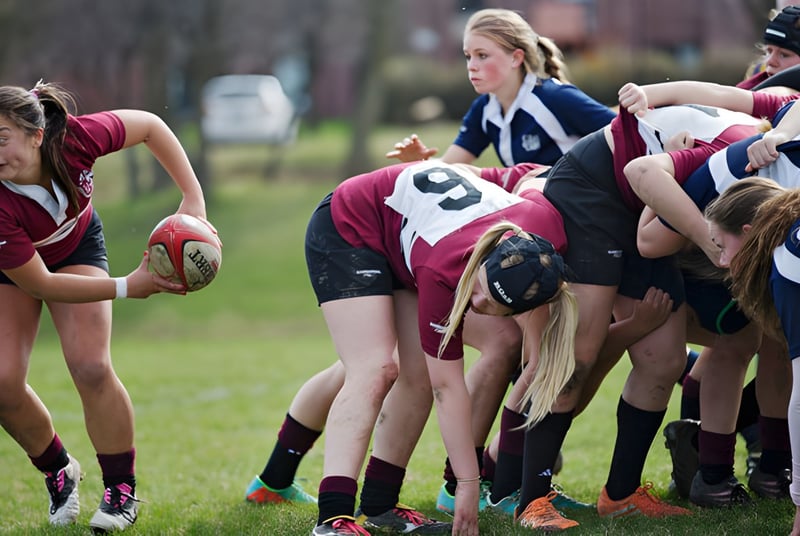 Un grupo de jugadoras de rugby de la Trinity College School está en un agrupamiento en un campo de hierba.