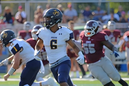 Un jugador de fútbol americano de la Trinity-Pawling School está en el campo junto a otros jugadores con diferentes camisetas.