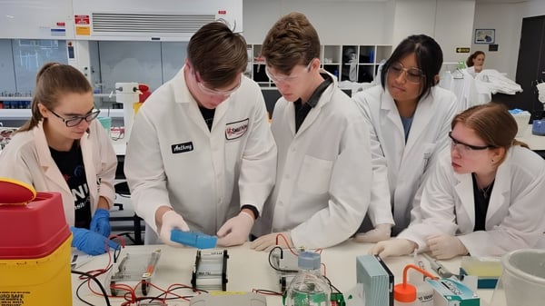 Estudiantes de la UC-Lake Ginninderra realizan juntos un experimento en el laboratorio de ciencias.