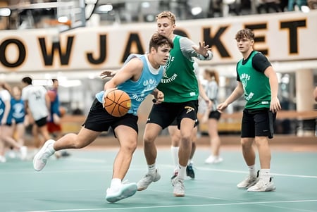 Un grupo de estudiantes juega baloncesto en el gimnasio de la University of Wisconsin-Superior frente a un gran cartel de LOWJACKETS.