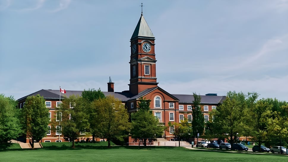 El Upper Canada College muestra un edificio de ladrillo con un alto campanario en un parque arbolado.