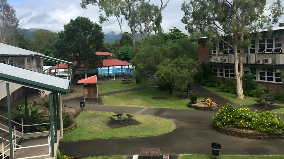 El campus verde con un camino curvado y edificios con techos rojos de la Urangan State High School.