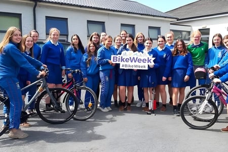 Estudiantes de la Ursuline Secondary School Thurles están con bicicletas frente a un edificio durante la acción BikeWeek.