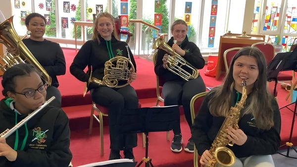 Un grupo de jóvenes músicos toca en el escenario de la Ursuline Secondary School en Cork instrumentos de metal.