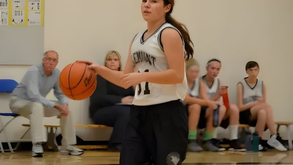 Una estudiante de la Valemount Secondary School dribla un balón de baloncesto en la cancha de baloncesto.