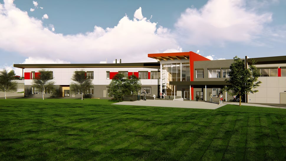 El moderno edificio de varios pisos de la Valleyview Secondary School se encuentra en un prado bajo un cielo nublado.