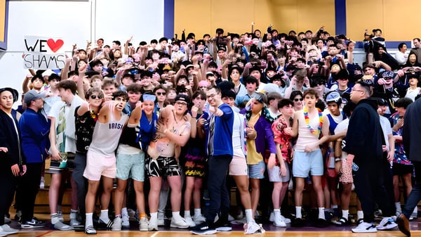 Un grupo de estudiantes en el interior con un cartel 'We ♥ SHAMS' en el campus del Vancouver Community College.