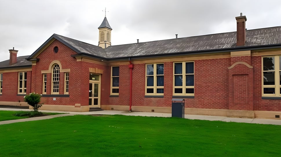 El edificio de ladrillo rojo con una alta torre se encuentra en el terreno de la Victor Harbor High School.