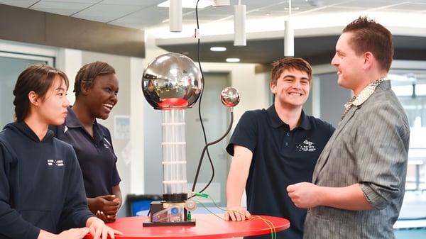 Cuatro personas están llevando a cabo una reunión de trabajo en el campus de la Victor Harbor High School.