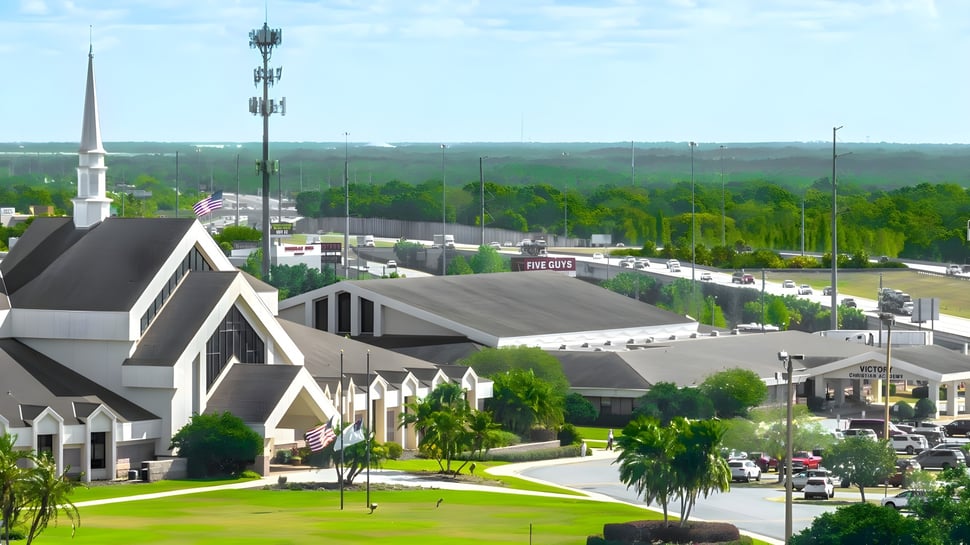 Vista de la ciudad con una iglesia destacada y una calle concurrida cerca de la Victory Christian Academy.