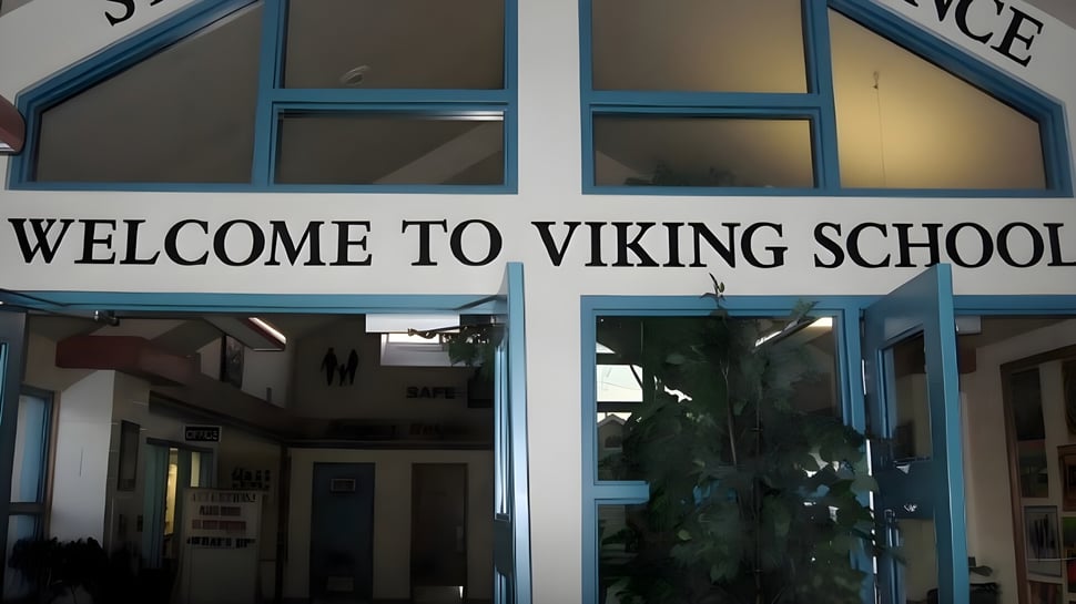 La entrada de la Viking School con un gran cartel de bienvenida sobre la puerta y vista al pasillo a través de las ventanas de vidrio.