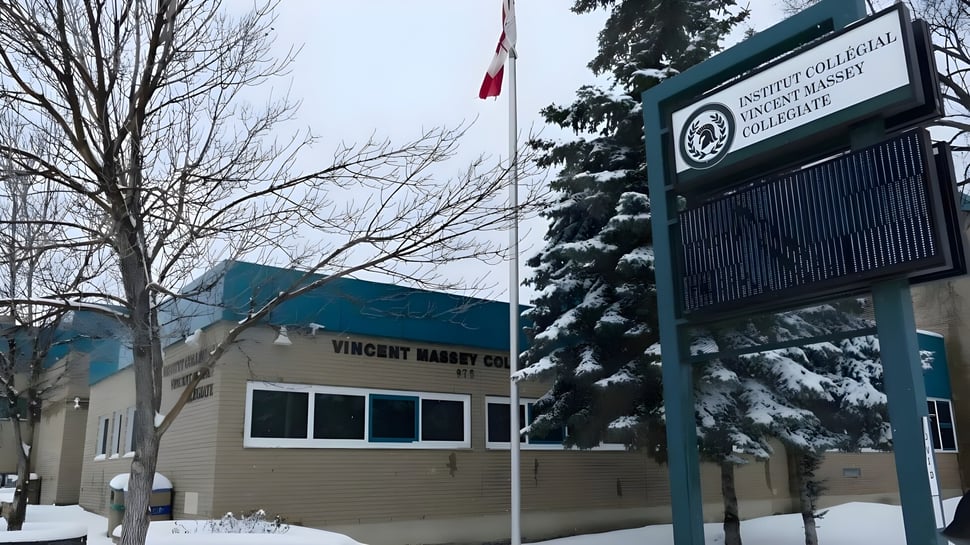 El Institut Collégial Vincent Massey Collegiate muestra un edificio rodeado de un paisaje cubierto de nieve con una bandera canadiense en primer plano.