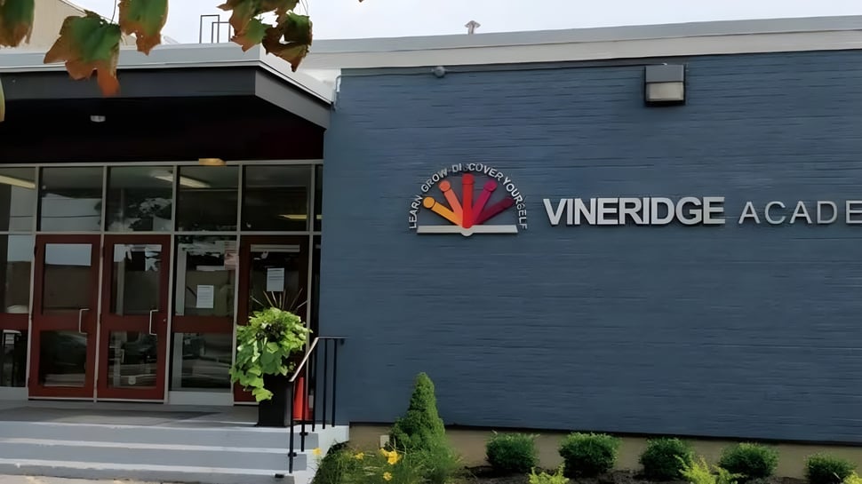 El edificio de la Vineridge Academy con fachada azul oscuro y plantas en primer plano.