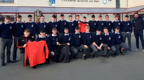 Un grupo de estudiantes en uniforme posan frente a un edificio en el campus del Virginia College.
