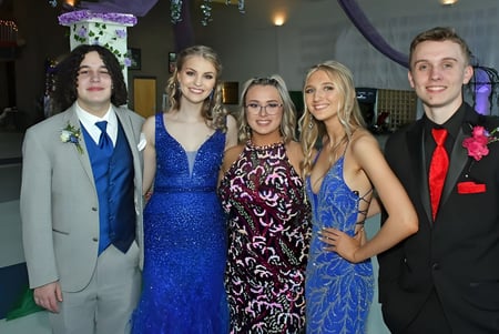 Un grupo de cinco estudiantes del Virginia College posan con ropa festiva en un evento especial.