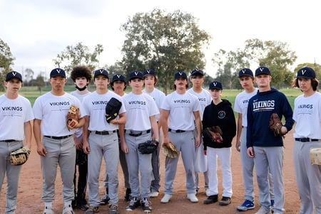 Un grupo de estudiantes de béisbol de la Vistamar School está juntos en el campo de béisbol.