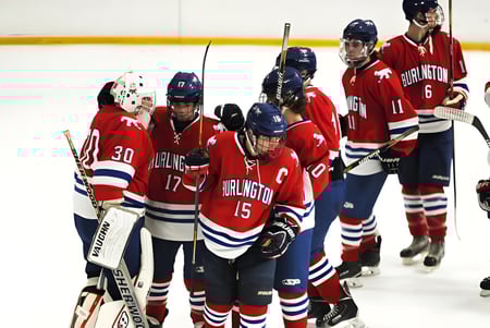 Estudiantes de la W.F. Herman Academy Secondary School juegan hockey en la pista de hielo en la arena deportiva.