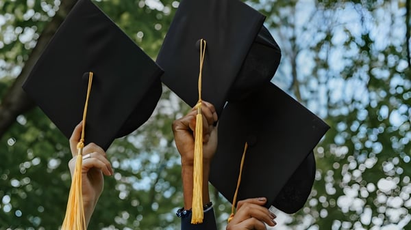 Dos gorros de graduación negros con borlas doradas se sostienen en el campus del Walkerville Collegiate Institute.