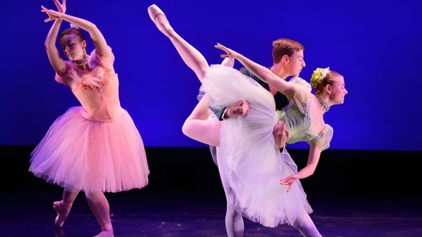 Estudiantes de la Walnut Hill School for the Arts realizan una actuación de ballet en un escenario con fondo azul.