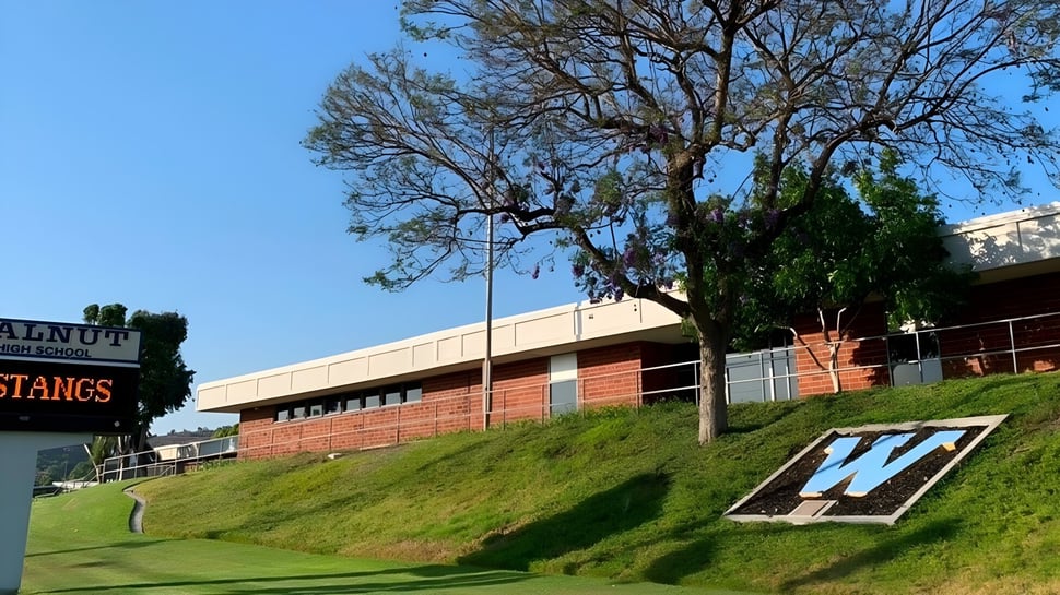 El edificio de ladrillo con un gran signo W en una pendiente cubierta de hierba en el Walnut Valley School District.