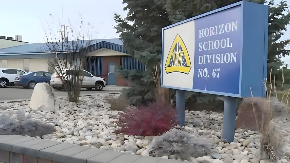 El letrero de la Warner School & Warner Hockey School con el edificio escolar y el jardín de fondo.