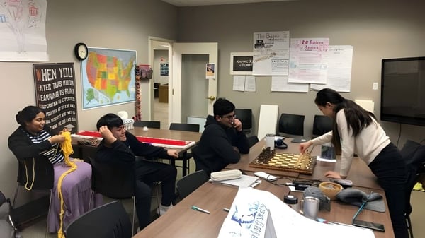 Un grupo de estudiantes trabaja en conjunto en una mesa en el salón de estudios de la Washington Preparatory School.