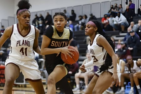 Tres jugadoras de baloncesto, una de la Wellington Heights Secondary School, juegan en la cancha de baloncesto.