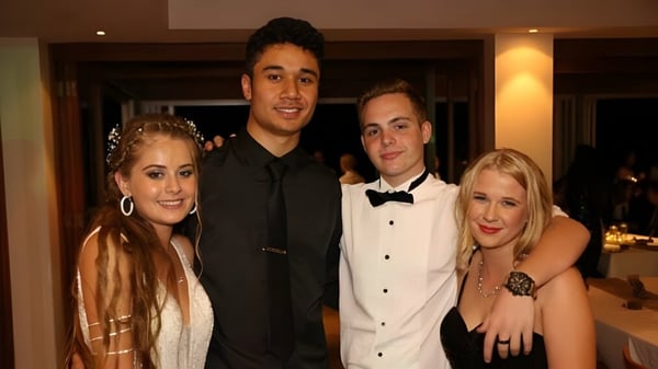 Un grupo de cuatro personas vestidas de manera formal posan juntas en un evento de la Wellington Point State High School.