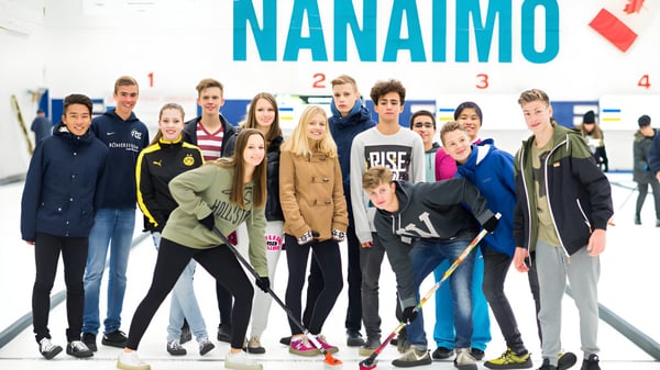 Estudiantes de la Wellington Secondary School posan juntos frente al gran letrero de Nanaimo.