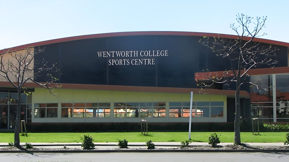 El Wentworth College muestra su gran centro deportivo con techo curvado y vegetación circundante.
