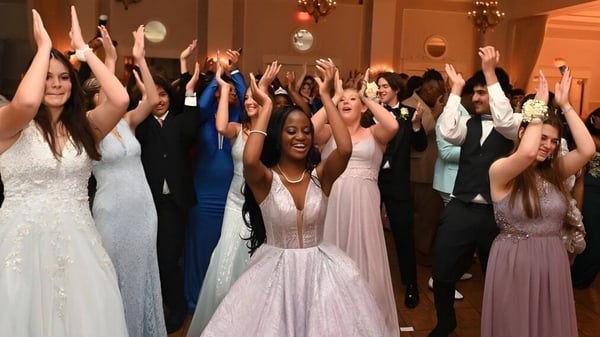 Un grupo de personas en ropa formal celebra juntos en un evento del Wesley College.