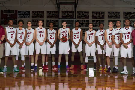 Un grupo de estudiantes de la West Nottingham Academy posan juntos en la cancha de baloncesto con pancartas de fondo.