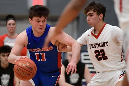 Dos estudiantes de la Westmount High School juegan baloncesto entre sí en la cancha.