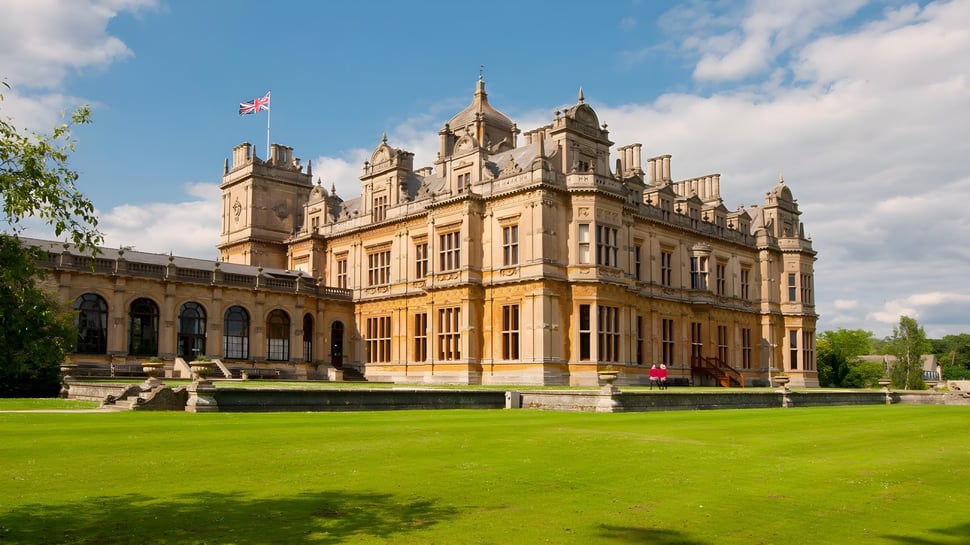 El castillo en el terreno de la Westonbirt School se encuentra bajo un cielo despejado y un amplio césped.