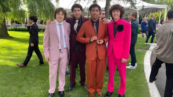 Un grupo de cinco personas con trajes coloridos está en el parque en el terreno de la Westwood High School.