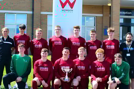 Un grupo de estudiantes posando frente al edificio con el letrero del Weymouth College.