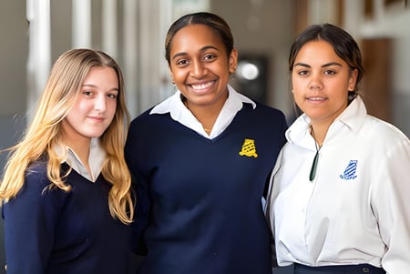 Tres estudiantes están juntos en el pasillo de Whanganui Girls’ College.